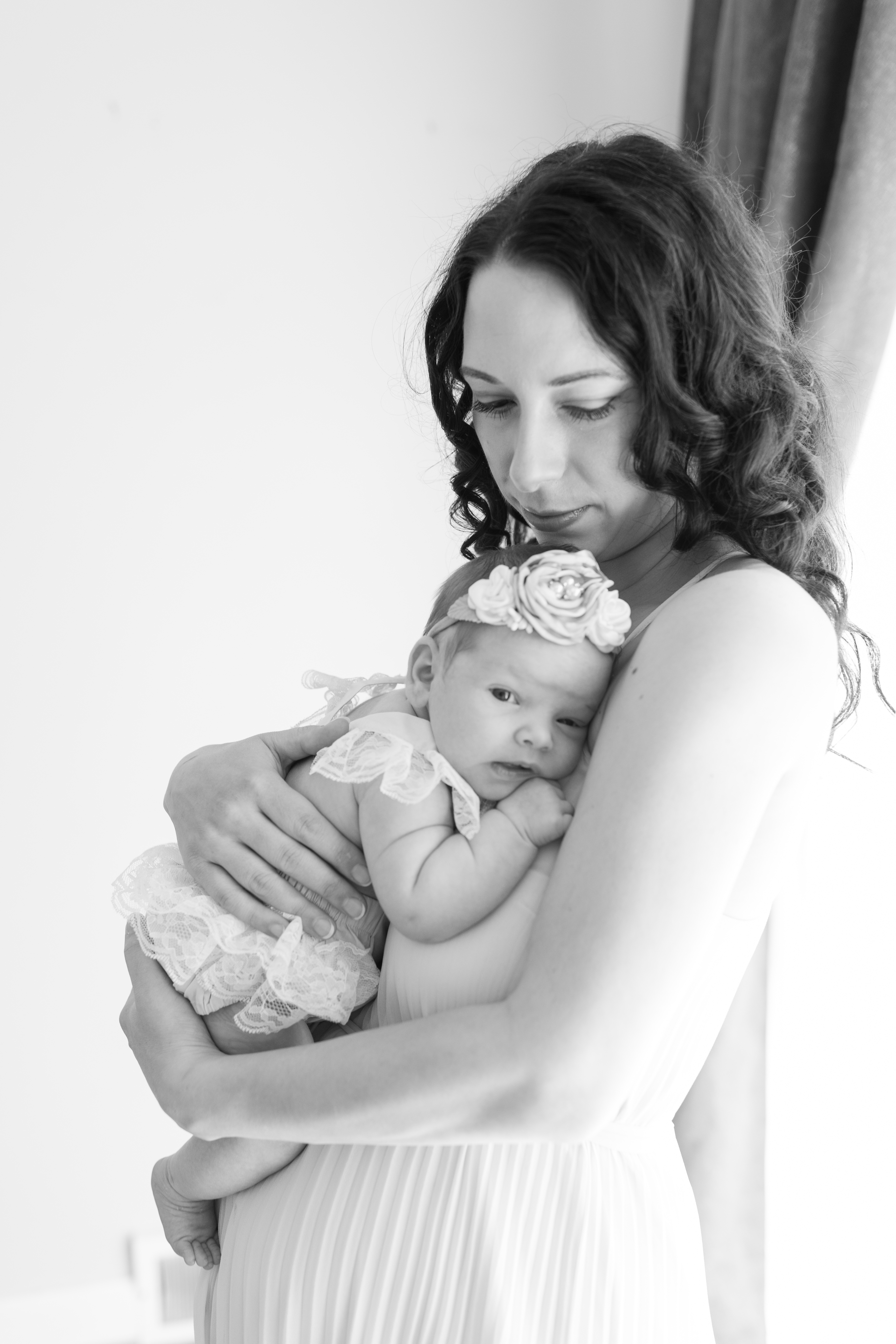 Black and white photo of mom holding new baby girl 