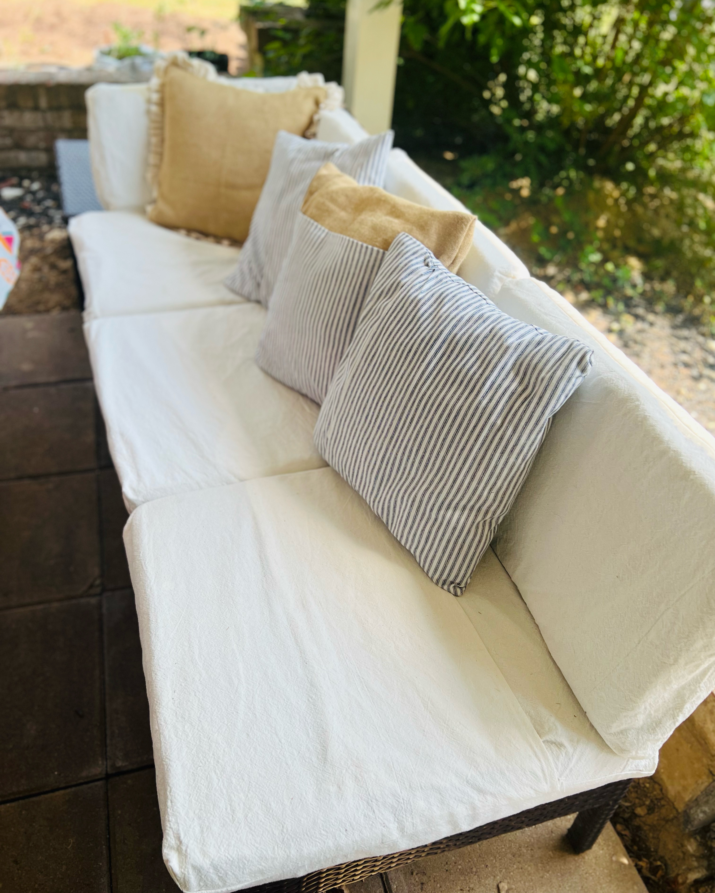 Patio bench with drop cloth covers and ticking and burlap pillows