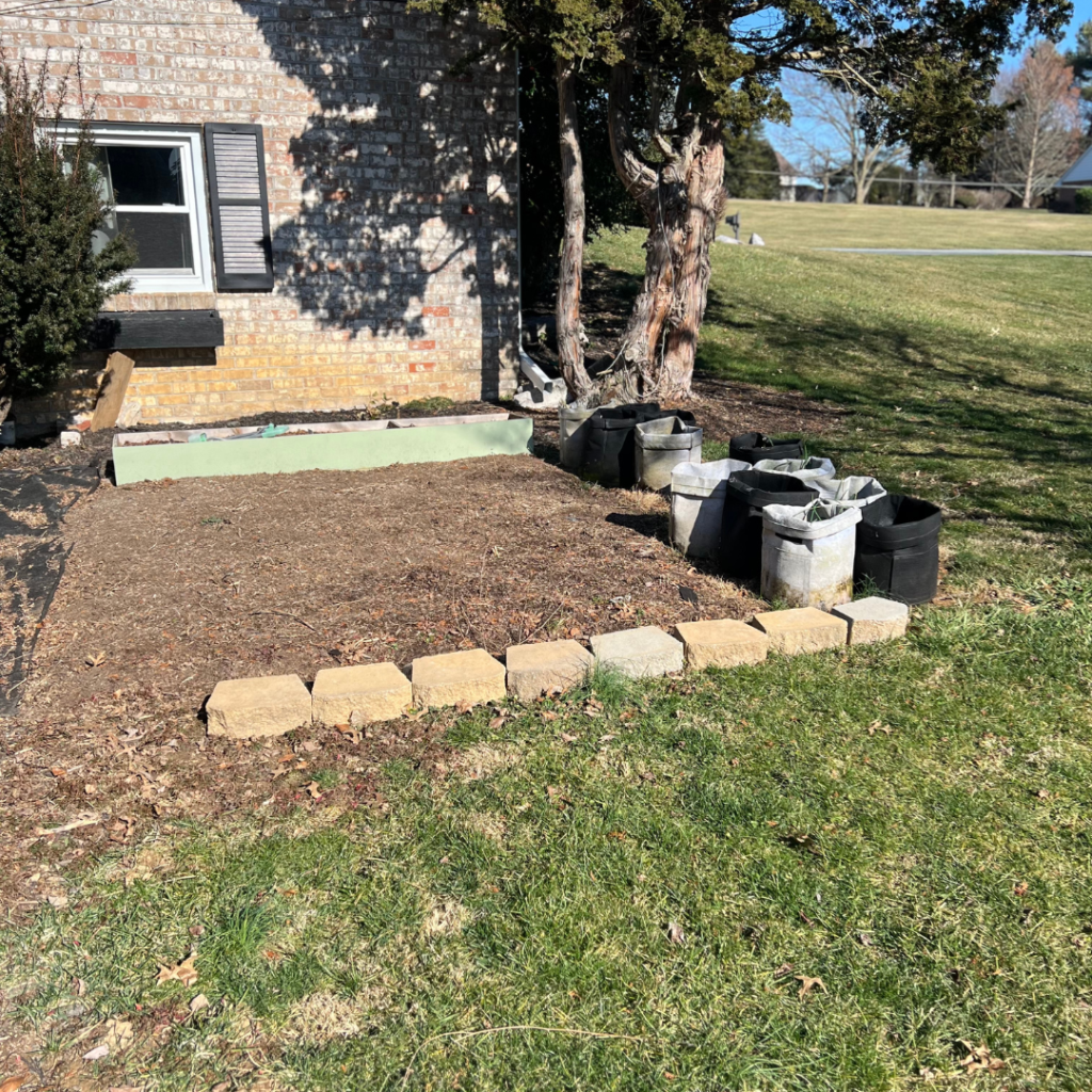 dirt plot with raised beds and keystone blocks